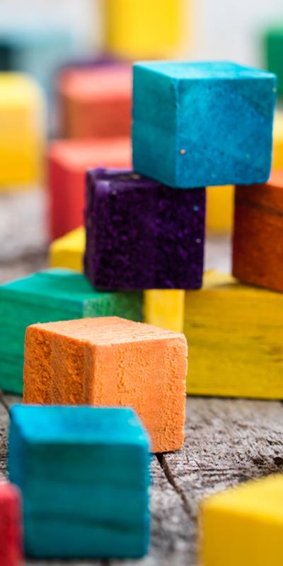 Child's coloured building blocks stacked unevenly on top of each other