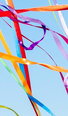 Coloured ribbons and streamers blowing against a blue sky